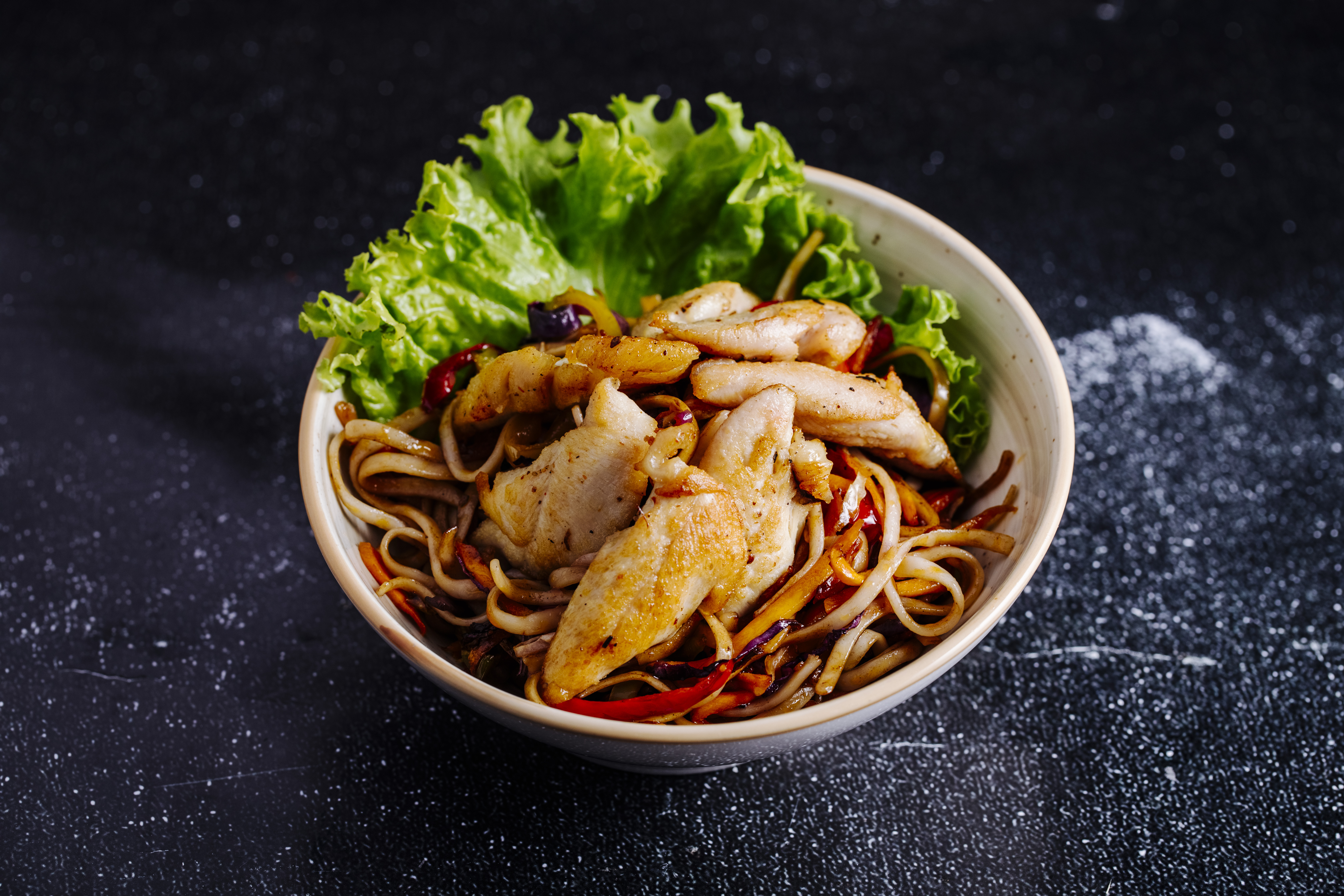 chinese noodles inside bowl with fillet lettuce